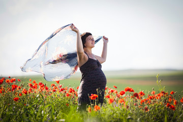Pregnant woman in a flowering poppy field