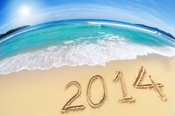 wide angle shot of beach with blue sky and 2014 year digits