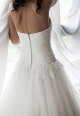 Fototapeta na wymiar bride in white wedding dress looking in window