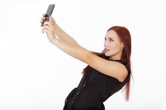 Attractive young woman with red hair takes a self portrait with