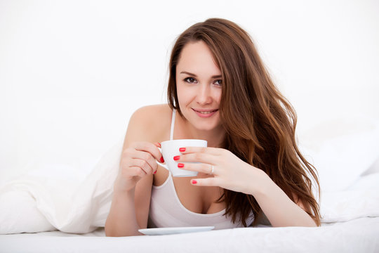 Woman in bed drinking tea