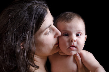Mother kiss on low key portrait.