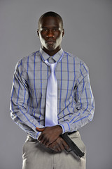 Man in shirt and tie holding a gun in his hands