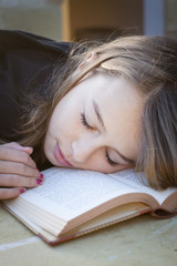 Student sleeping over book