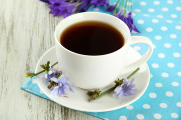 Cup of tea with chicory, on wooden background