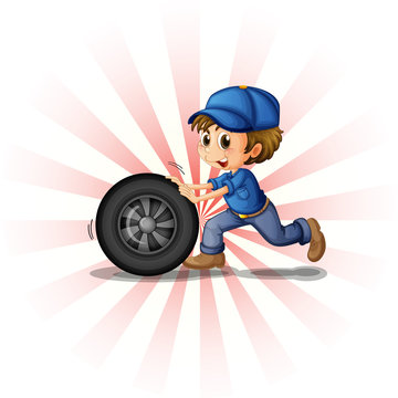 A young boy rolling a tire