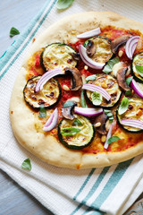 Pizza with griled courgette, mushrooms and pine nuts