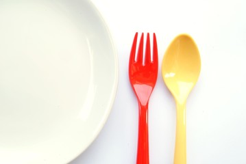yellow spoon and red fork with dish