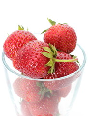 Fresh strawberries and glass isolated on white