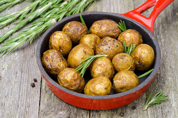 Baked potatoes with rosemary in frying pan horizontal