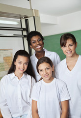 Fototapeta premium Teacher Standing With Female Students In Science Lab