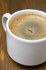 cup of black coffee with froth close-up