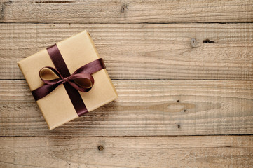 Vintage gift box with bow on wooden background