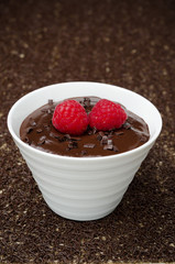 delicious chocolate mousse with fresh raspberries in white bowl