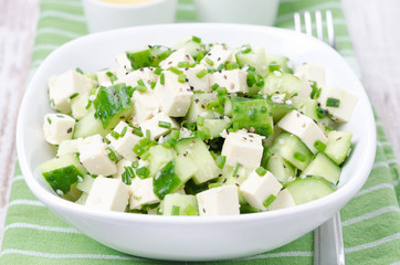 salad with cucumber, tofu, green onions and sesame seeds closeup