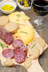 salami, cheese, crackers, olives and a glass of wine
