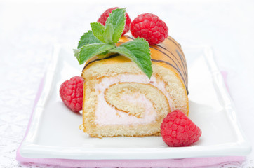 swiss roll with raspberry cream on the plate