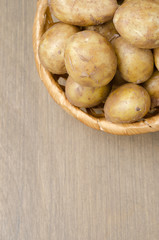 Fototapeta na wymiar top view of new potatoes in a basket on a gray wooden background