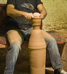hands of a potter, creating an earthen jar on the circle