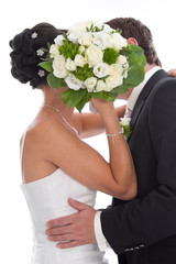 Kuss - Brautpaar isoliert küsst sich vor dem Brautstrauß