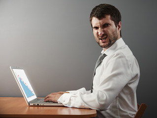 angry businessman working with laptop