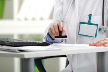 a doctor putting stamp on a document