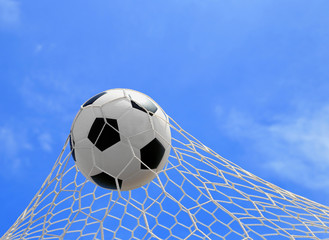 soccer ball in net on blue sky