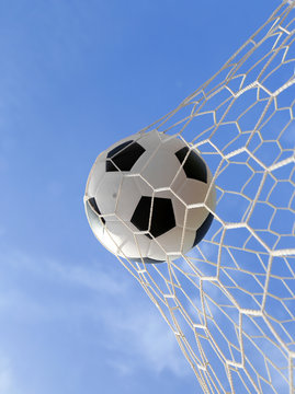 soccer ball in net on blue sky