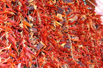 Rows of red chilli peppers hanging on a market stall