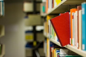 red book popping out a bookshelf