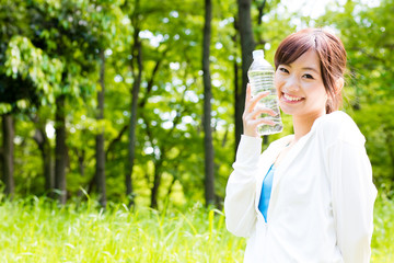 young asian woman with drinking water in the park