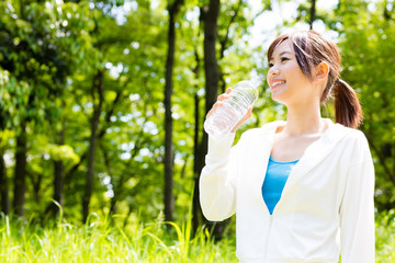 young asian woman with drinking water in the park