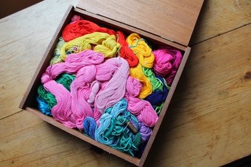 Wooden box filled with colorful embroidery floss