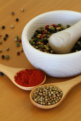 Mixed spices on wooden spoons and in wooden mortar