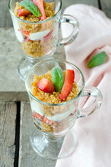 Dessert from sponge cake , strawberries and cream in a glass