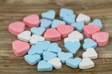 Colorful sugar hearts on wooden surface