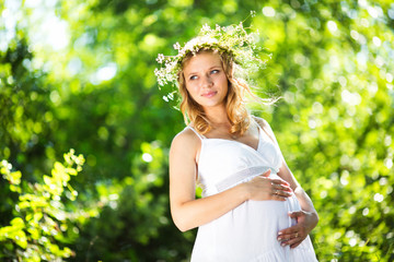 Pregnant woman in green forest