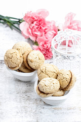 Parisian macaroons on white wooden table. Pink carnation flowers