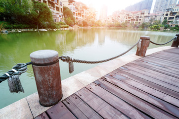Naklejka premium platform beside lake with sunset in park