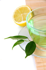 Transparent cup of green tea with lemon