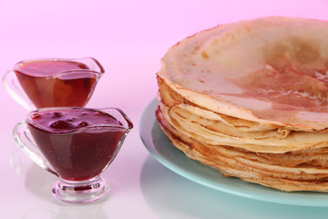 Pancakes on plate on pink background
