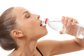 Woman in fitness wear drinking water, isolated on white