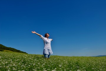 Fototapeta premium young woman with spreading arms to sky