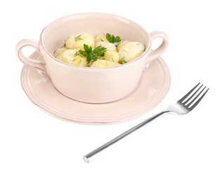 Tender young potatoes with sour cream and herbs in pan isolated