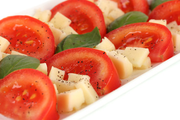 Cheese mozzarella with vegetables in the plate close-up