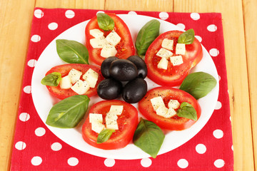 Cheese mozzarella with vegetables in plate on table