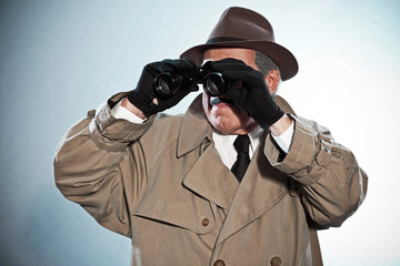 Vintage detective with mustache and hat. Looking through binocul