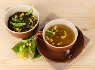 Cup of tea with linden on napkin   wooden table
