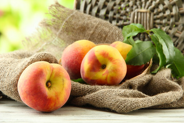 Ripe sweet peaches on wooden table in garden, close up