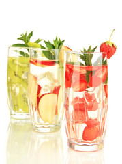 Glasses of fruit drinks with ice cubes isolated on white